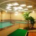 Indoor pool area at Guohao Hotel in Shijiazhuang with curved pool, hot tub and skylit ceiling