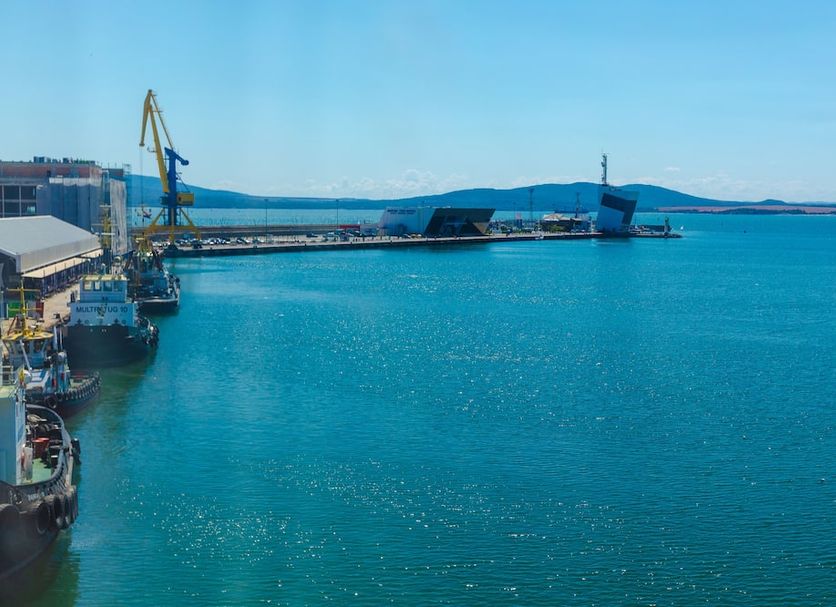 Marina Burgas Hotel in Burgas overlooking a blue harbor with cranes, docked ships and calm sea