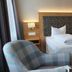 Eden Hotel in Bad Krozingen guest room with twin beds, armchair, and small table