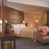 Shangri-La Baotou guest room with king bed, seating area, TV, and city-view window