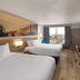 Days Inn by Wyndham Harrisonburg room with two beds, wall art, desk, and city view