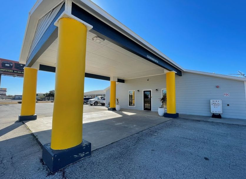 Kenedy Inn and Suites in Kenedy exterior with yellow columns and covered entrance
