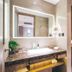 Binhai Jianguo Hotel Tianjin bathroom with vanity, mirror, lit shelves, and toilet
