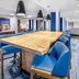 Holiday Inn Express & Suites Colorado Springs-First & Main breakfast area with communal table and blue chairs