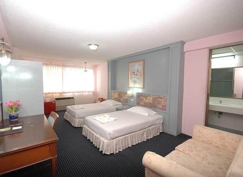 Lopburi Inn Hotel in Lop Buri guest room with two twin beds, dresser, window, and seating area