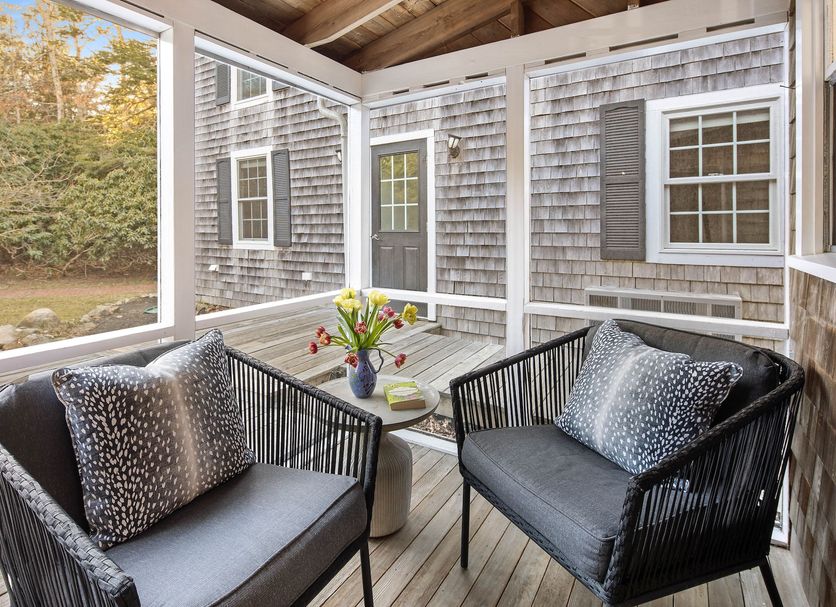 Lambert's Cove Inn & Resort in West Tisbury screened porch seating area with cushioned chairs and table