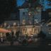 Dwór Sieraków in Sieraków (Małopolskie) at dusk with lit terrace seating and a large umbrella