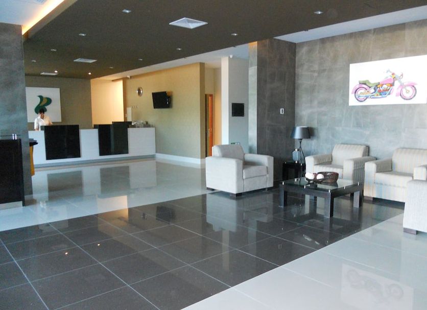 Hotel Diego de Almagro Chillan lobby seating area with modern chairs and glossy tile floors in Chillán