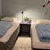 Svea Hostel Stockholm twin room with two single beds, nightstand, and wall lamps
