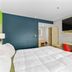 Signature Inn Berkeley guest room with king bed, desk, wall-mounted TV and bathroom doorway