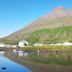 Við Lónið Guesthouse in Seydisfjordur with mountain and waterfront reflections