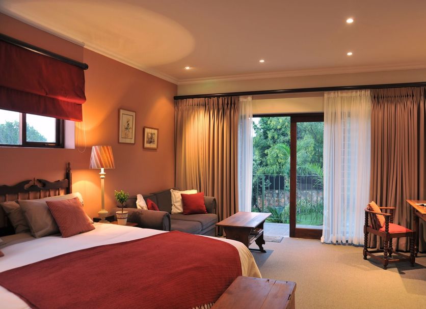 Claires of Sandton Luxury Guest House room in Sandton with king bed, sofa, desk and garden-view doors