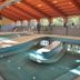 Indoor pool at Hotel Hajnal in Mezőkövesd with curved water features and a wood-beamed ceiling