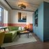 The July - Boat & Co in Amsterdam: suite with green sofa, bed, and teal partition wall