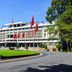 Funny Guesthouse in Ho Chi Minh City with white facade, red flags, and a landscaped lawn