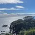 Lottin Point Motel in Hicks Bay with ocean views, green lawns, and coastal cliffs under a blue sky
