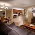 Oakwood Falls Church in Falls Church: furnished suite with kitchen, dining area, sofa, TV and floor lamp