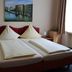 Stadthotel Augsburg guest room with twin beds, bedside tables and window curtains in Augsburg