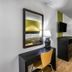 Motel 6 Augusta Ks room with desk, wall mirror, TV, and window seating area in Augusta