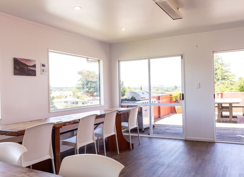 Haka House Taupo in Taupo meeting room with long table, chairs and sliding doors to terrace