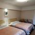 Sin Fu Business Hotel, Taichung City: twin beds in a simple guest room with bedside table and chairs
