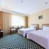 Long Ge Hotel in Beijing guest room with two twin beds, desk, and large window with curtains
