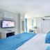 Glamour Hotel Istanbul Sirkeci room with blue tufted headboard, wall-mounted TV and vanity in Istanbul
