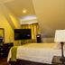 Elite Hotel Port Au Prince guest room with bed, TV, dresser and sloped ceiling