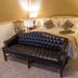 Fairfield Manor Bed and Breakfast in Shreveport room with bed, black tufted sofa, and bedside lamps