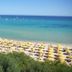 Th Costa Rei - Free Beach Resort in Costa Rei with rows of yellow umbrellas on a sandy beach and turquoise sea