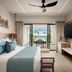 Secrets Tides Punta Cana room with ocean-view balcony, wall-mounted TV, and king bed in Uvero Alto