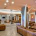 Hotel Club Astor in Ugento lobby with leather sofas, tiled floor, and modern curved columns