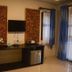 Phu Chom Mork Resort in Sangkhla Buri room with wall-mounted TV, desk, mini fridge and curtains