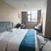 Days Inn by Wyndham Wuxi Shengma guest room with king bed, desk, chairs, and window view in Wuxi