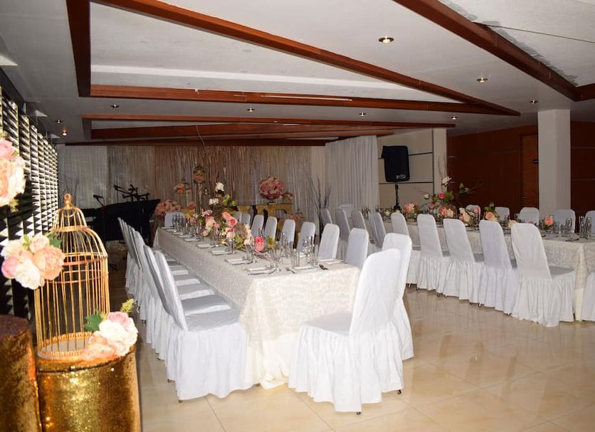 Hotel Principe Chetumal banquet hall with long decorated dining tables and white chair covers