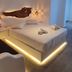 Eternal Suites in Mykonos bedroom with glowing bed base, pendant light, and wooden wall art