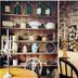Live and Let Live Inn in Totnes dining room with wooden shelves, stacked logs, and candlelit table