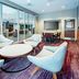 Courtyard by Marriott Toledo West lobby lounge with round tables, chairs, and floor-to-ceiling windows in Toledo