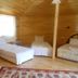 Fire pansiyon in Cirali: wood-paneled guest room with three single beds and a patterned rug