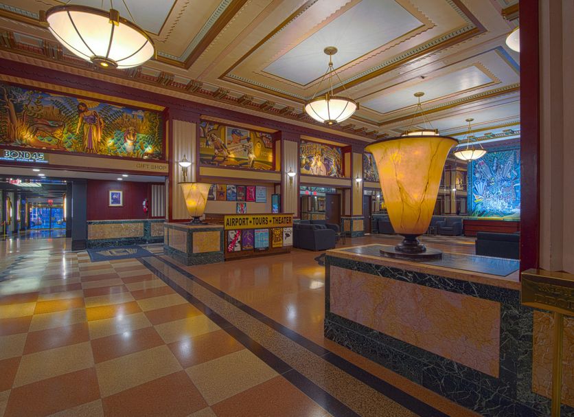 Hotel Edison Times Square lobby in New York with colorful art deco decor and large chandelier lighting