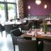 Europa Kehl Hotel in Kehl dining room with set tables, black chairs and purple walls