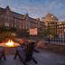 Club Wyndham Long Wharf in Newport with a fire pit seating area and historic waterfront building at dusk