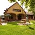 Premier Inn Glasgow East in Glasgow with a grassy outdoor patio, picnic tables, and shaded seating