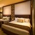 The Arnawa Hotel Pangandaran twin-bedded guest room with warm lighting and patterned headboard