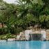 CC Beach Front Hotel in Playa Hermosa: tropical pool with rock waterfall and lush palms
