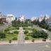 Sea Shore Garden Hotel Qingdao in Qingdao with landscaped gardens, road, and distant city skyline