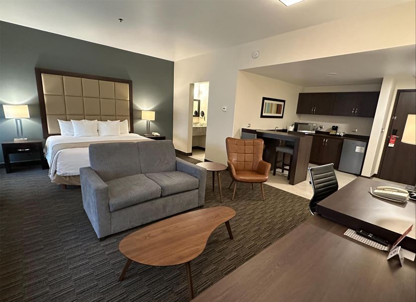 Best Western Plus Chihuahua Juventud suite with bed, sofa, desk and kitchenette in Chihuahua
