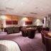 The Lodge At Meyrick Park in Bournemouth lounge with round tables, armchairs and carpeted seating area