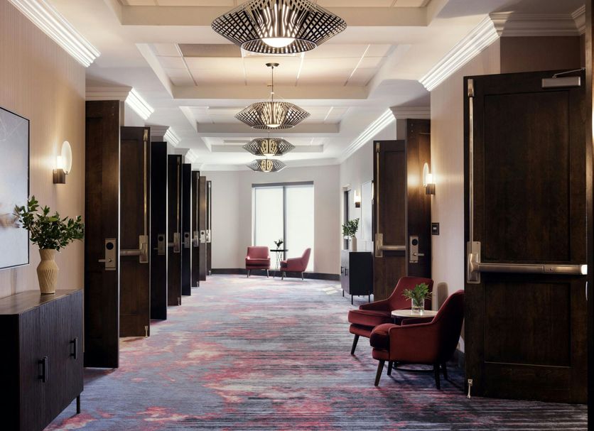 Sheraton Nashville Brentwood hallway with patterned carpet, lounge chairs, and bright windows in Brentwood