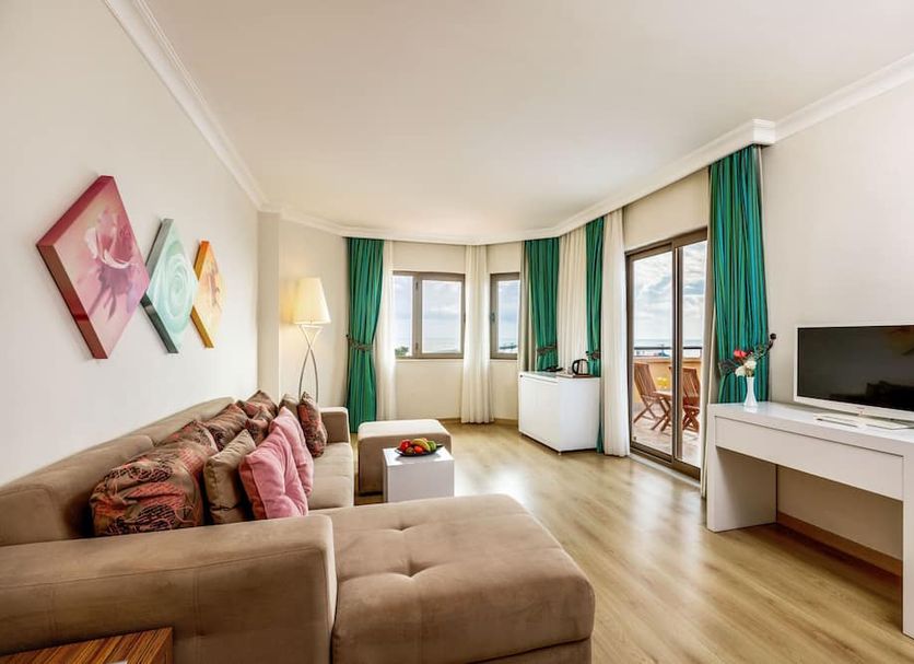 Asteria Family Resort Belek in Serik, spacious suite with sofa, TV desk, and balcony doors to outdoor seating